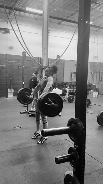 The squat rack and loaded barbell in the Bar None training space